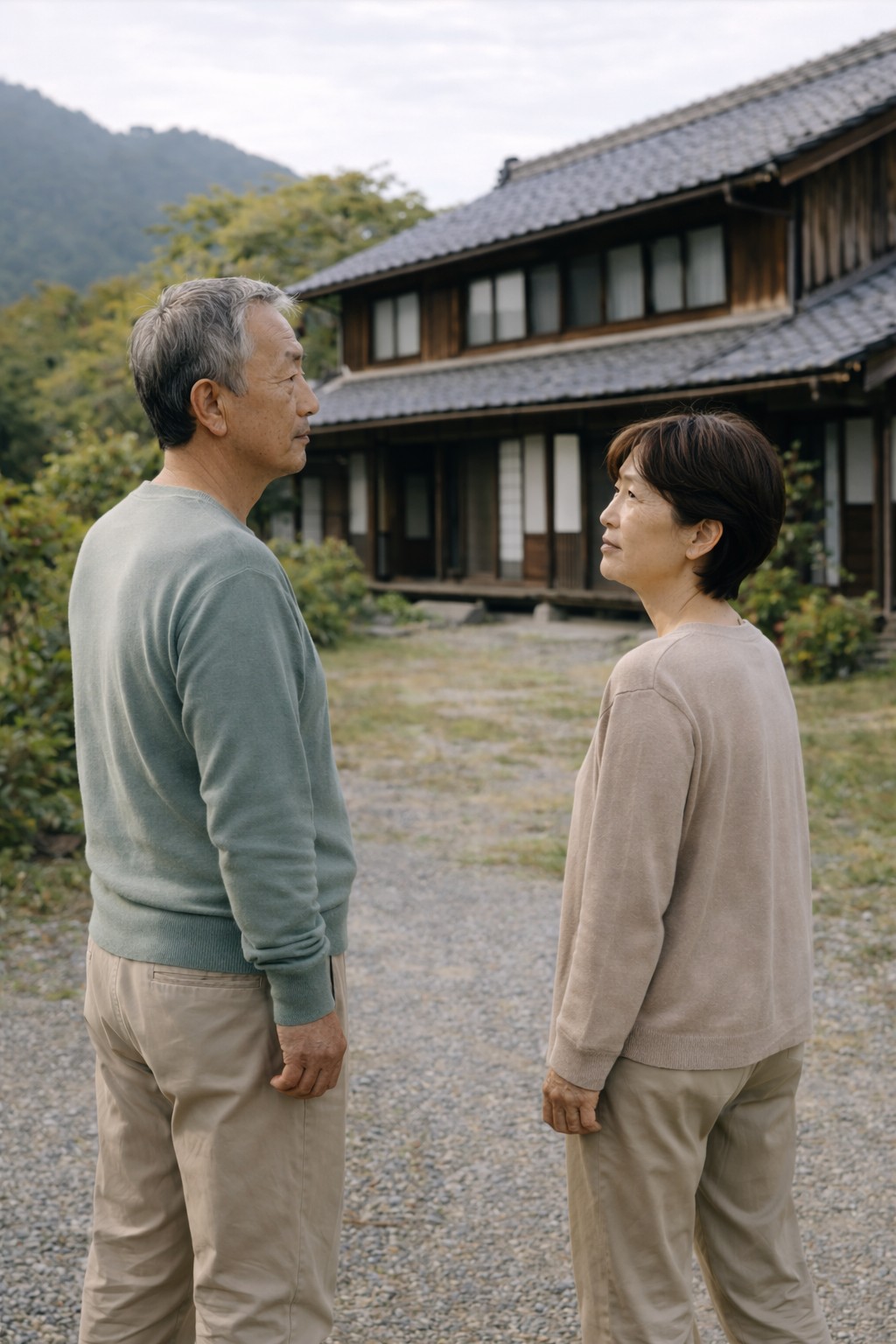 田舎の家を前に、これからの住まいについて考え込む60代の日本人夫婦