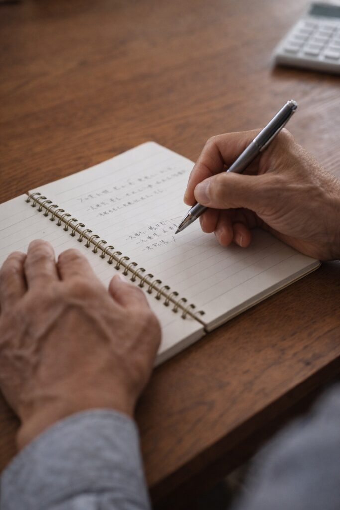 ノートにゆっくり書き出す50代の手元